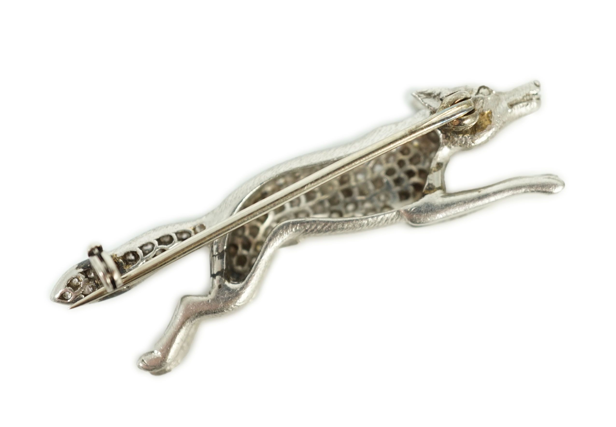 A Victorian style white gold, diamond encrusted and cabochon garnet set brooch, modelled as a running fox